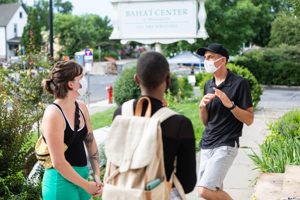 Volunteer Everett Ayoubzadeh talks with community members outside the Baha’i Center in Minneapolis by George Floyd Square, where a pop-up food distribution site turned into a long-term food pantry