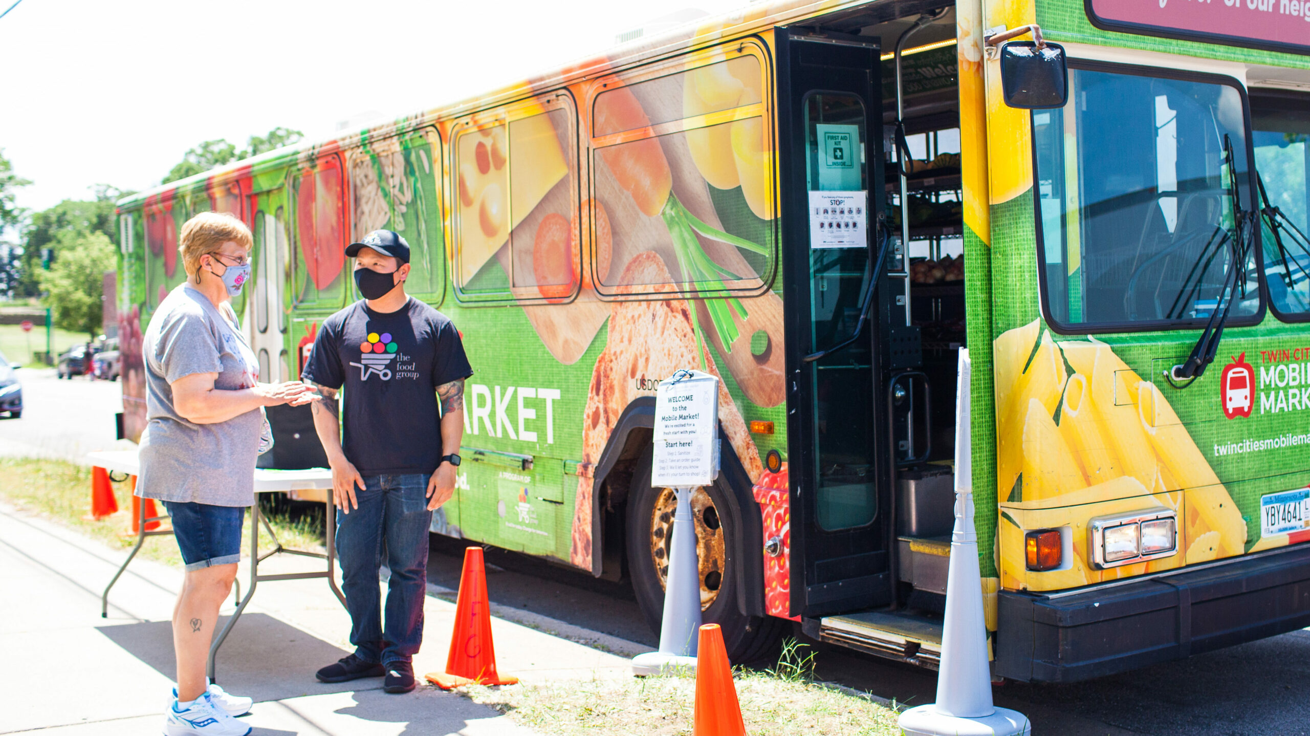 twin cities mobile market bus with open doors and two people about to board and shop